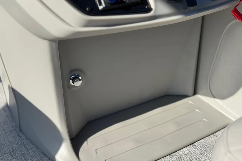 Slide: The Image of 2026 Berkshire 22RFX LE boat storage compartment with chrome knob and textured flooring. - 25