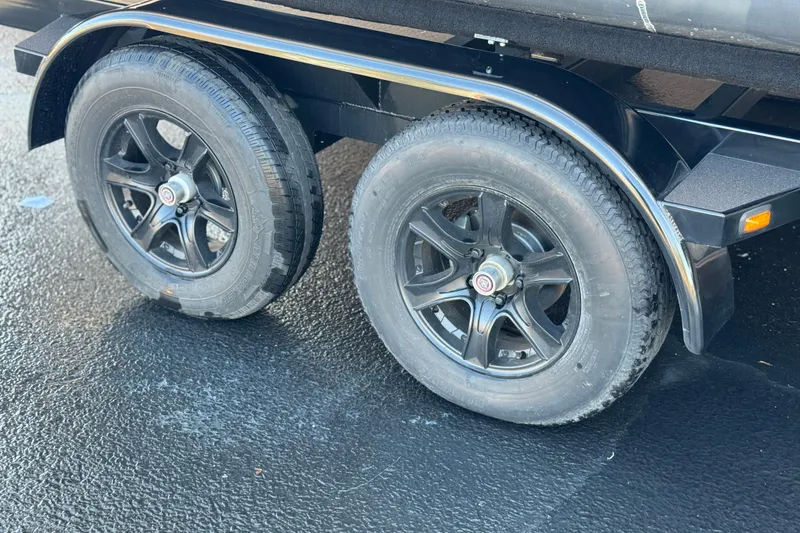 Slide: The Image of Trailer wheels of a 2026 Berkshire 22RFX LE on asphalt surface. - 26