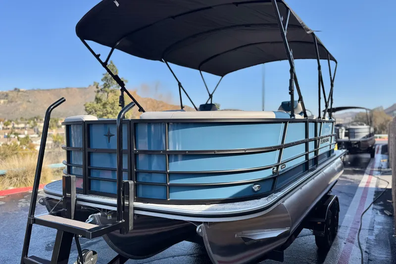 Slide: The Image of 2026 Berkshire 22RFX LE pontoon boat with canopy, parked outdoors. - 3