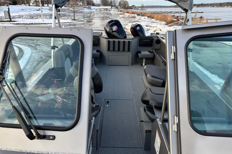 Slide: The Image of 2026 Crestliner 2050 Commander boat interior with dual outboard motors, docked by snowy shoreline. - 10