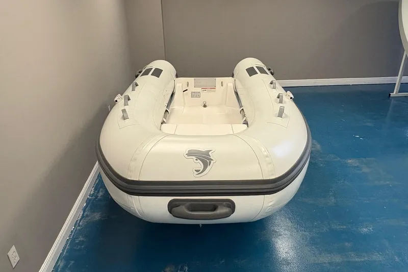 Slide: The Image of 2024 Caribe c-10X inflatable boat displayed indoors with promotional signage. - 5