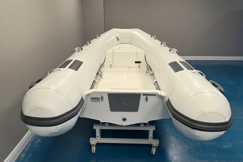 Slide: The Image of 2024 Caribe c-10X inflatable boat, white with gray accents, featuring oars and durable design. - 6