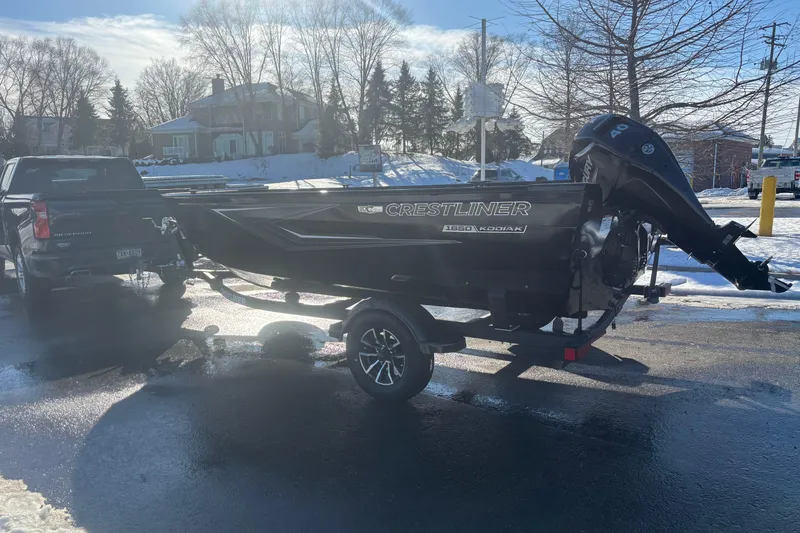 Slide: The Image of 2026 Crestliner 1650 Kodiak Tiller boat on trailer, parked in snowy setting. - 9
