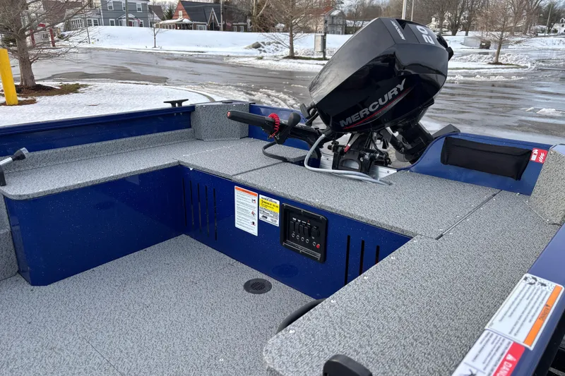 Slide: The Image of 2026 Crestliner 1650 Discovery Tiller boat with Mercury engine, parked on snowy pavement. - 7
