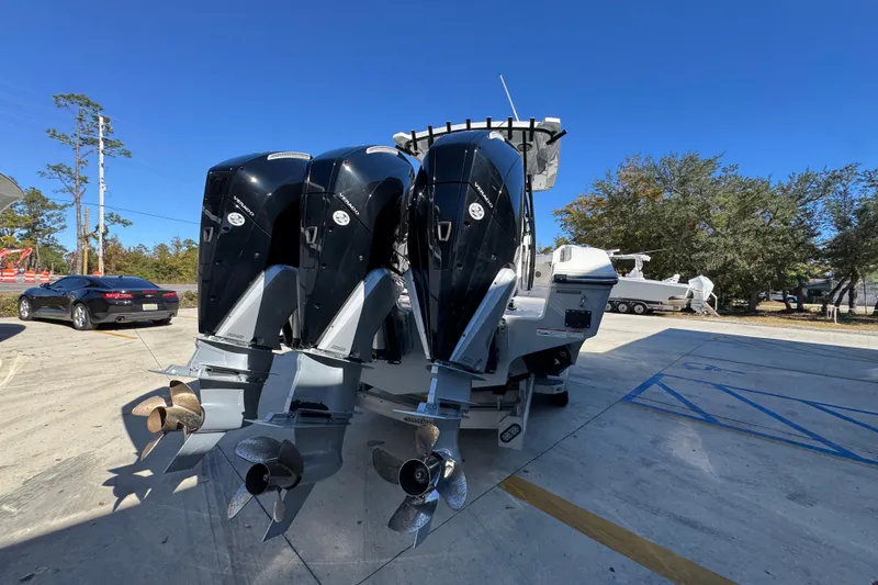 Slide: The Image of 2023 Fountain 34 Tournament Edition boat with triple outboard engines in a parking lot. - 12