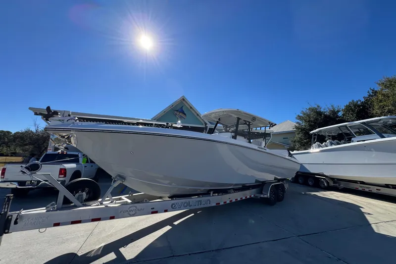 Slide: The Image of 2023 Fountain 34 Tournament Edition boat on trailer under bright sun. - 3