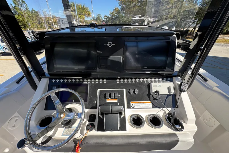 Slide: The Image of 2023 Fountain 34 Tournament Edition boat dashboard with steering wheel and navigation screens. - 33
