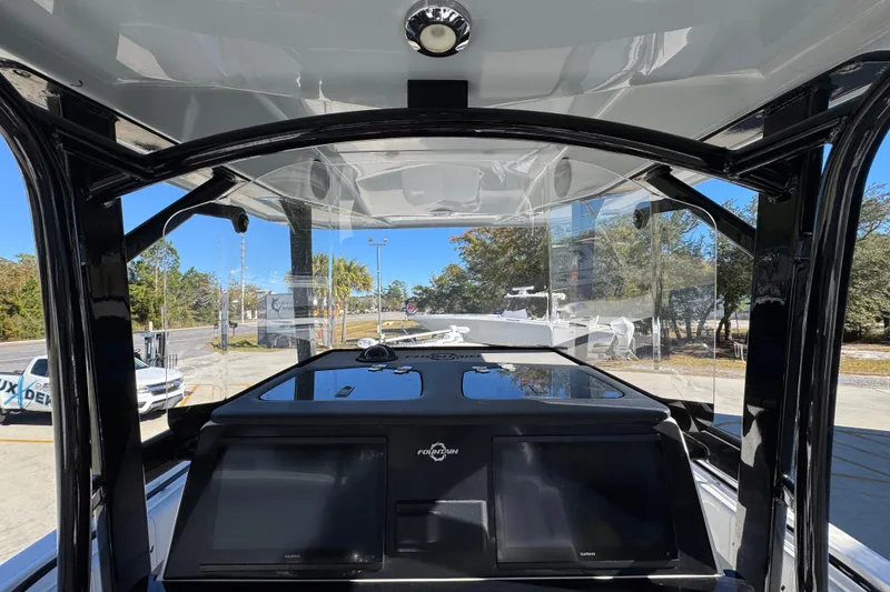 Slide: The Image of 2023 Fountain 34 Tournament Edition boat dashboard with navigation screens and overhead canopy. - 34