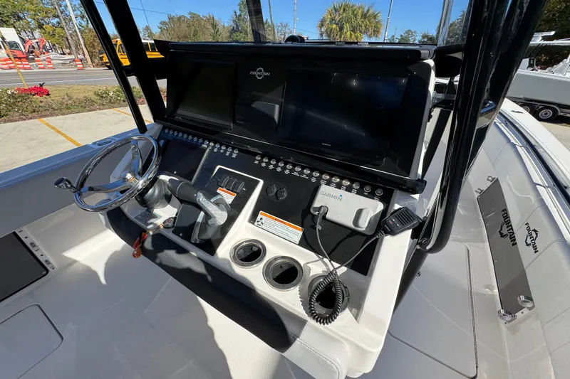 Slide: The Image of 2023 Fountain 34 Tournament Edition boat dashboard with steering wheel and navigation controls. - 35