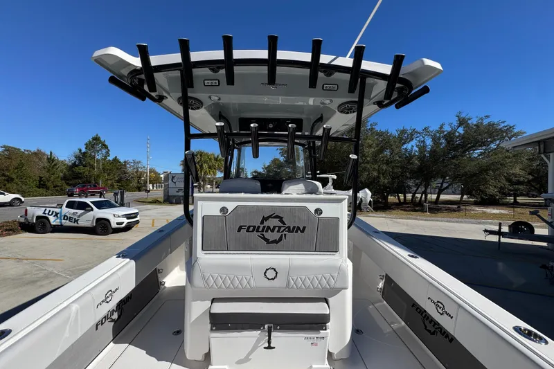 Slide: The Image of 2023 Fountain 34 Tournament Edition boat with T-top and rod holders, parked outdoors. - 38