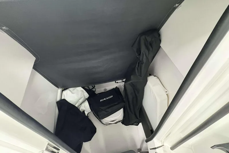 Slide: The Image of Interior storage compartment of 2026 Blackfin 222 CC boat with bags and covers. - 13