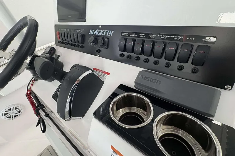 Slide: The Image of 2026 Blackfin 222 CC boat dashboard with controls, steering wheel, and cup holders. - 15