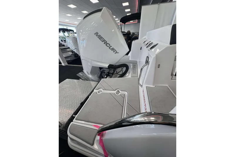 Slide: The Image of 2026 Blackfin 222 CC boat with Mercury engine, showcased indoors. - 20