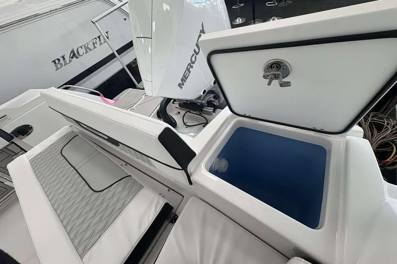 Slide: The Image of 2026 Blackfin 222 CC boat interior with seating and storage compartment open. - 22