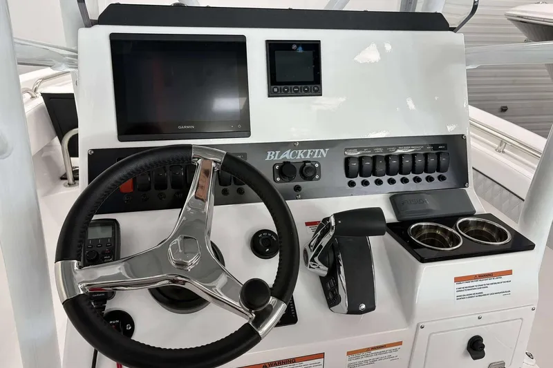 Slide: The Image of 2026 Blackfin 222 CC boat dashboard with steering wheel and control panel. - 24