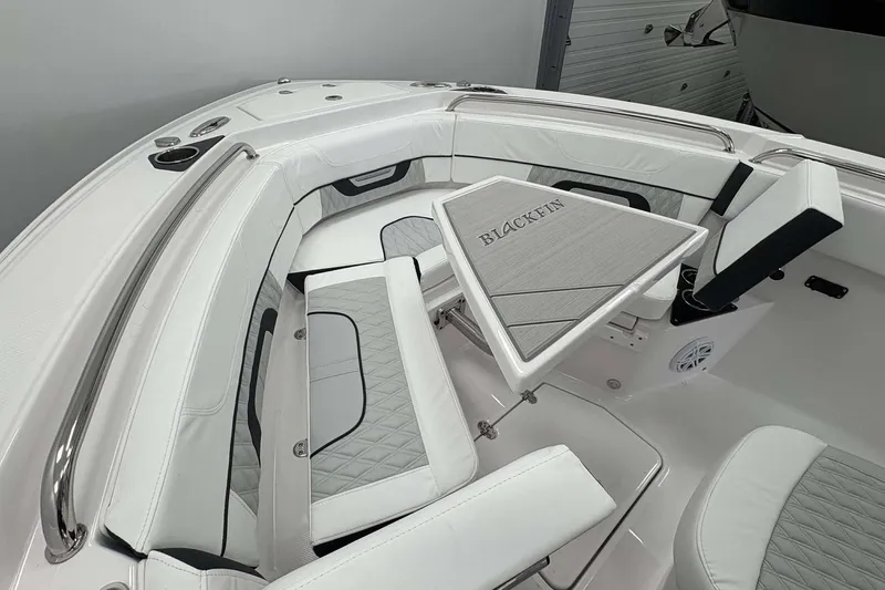 Slide: The Image of 2026 Blackfin 222 CC boat interior with cushioned seating and a triangular table. - 8
