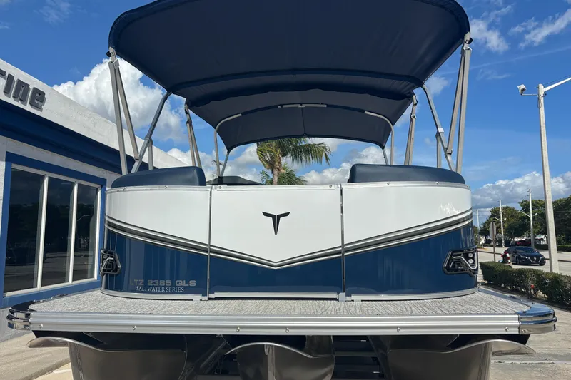 Slide: The Image of 2026 Tahoe Pontoons 23 LTZ Quad Lounge switch, blue and white, parked outdoors under blue sky. - 3
