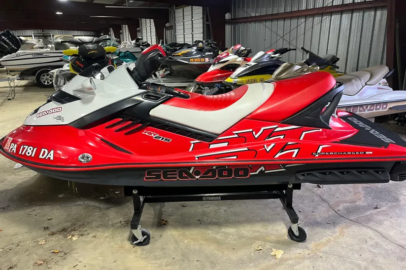 The Image of 2007 Sea-Doo RXT 215 jet ski in a storage facility, red and white design. - 0