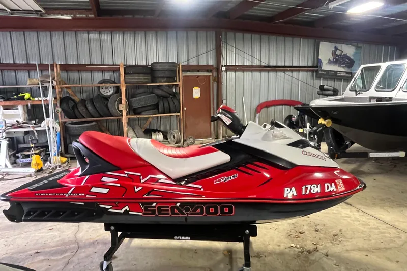 Slide: The Image of 2007 Sea-Doo RXT 215 jet ski in a garage, red and white design. - 3