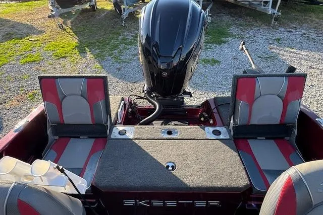 Slide: The Image of 2023 Skeeter Solera 189 boat interior with motor and seating, featuring red and gray design. - 13