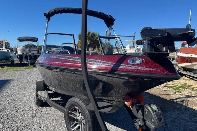 Slide: The Image of 2023 Skeeter Solera 189 boat with canopy, parked on a trailer in a marina. - 3
