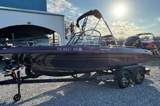 Slide: The Image of 2023 Skeeter Solera 189 boat on trailer, parked outdoors under sunny sky. - 5