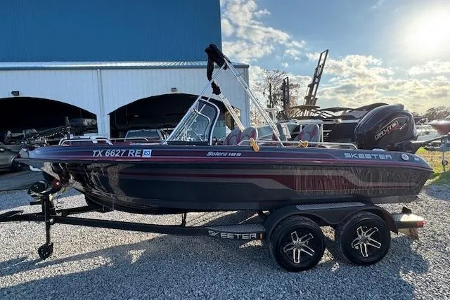 Slide: The Image of 2023 Skeeter Solera 189 boat on trailer, parked outdoors under a blue sky. - 6
