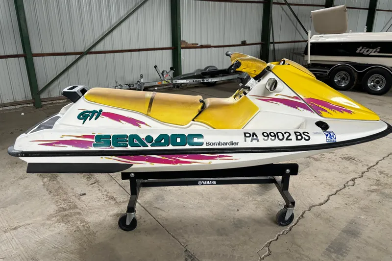 Slide: The Image of 1996 Sea-Doo GTI jet ski with yellow seat and vibrant graphics in a storage facility. - 5
