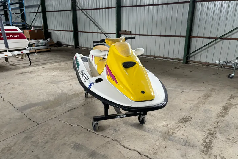 Slide: The Image of 1996 Sea-Doo GTI jet ski with yellow and white design in a storage facility. - 6