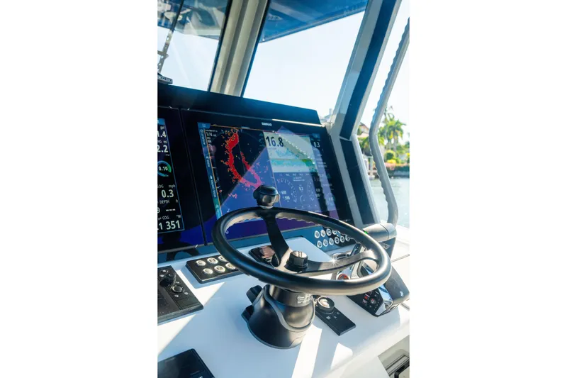 Slide: The Image of Cockpit of 2025 Costa Custom Boats 34, featuring advanced navigation displays and steering wheel. - 13