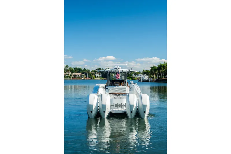 Slide: The Image of 2025 Costa Custom Boats 34 on serene water, clear sky, and waterfront homes in the background. - 3