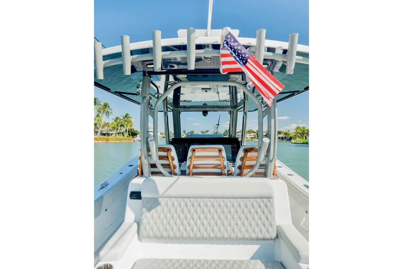 Slide: The Image of 2025 Costa Custom Boats 34 with American flag, docked in tropical waters. - 9