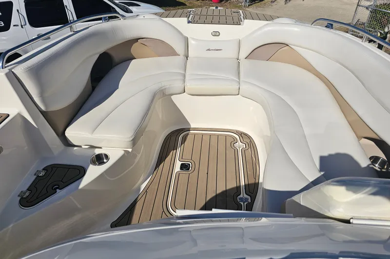 Slide: The Image of 2006 Hurricane SunDeck 260 OB boat interior with white seating and wood flooring. - 10