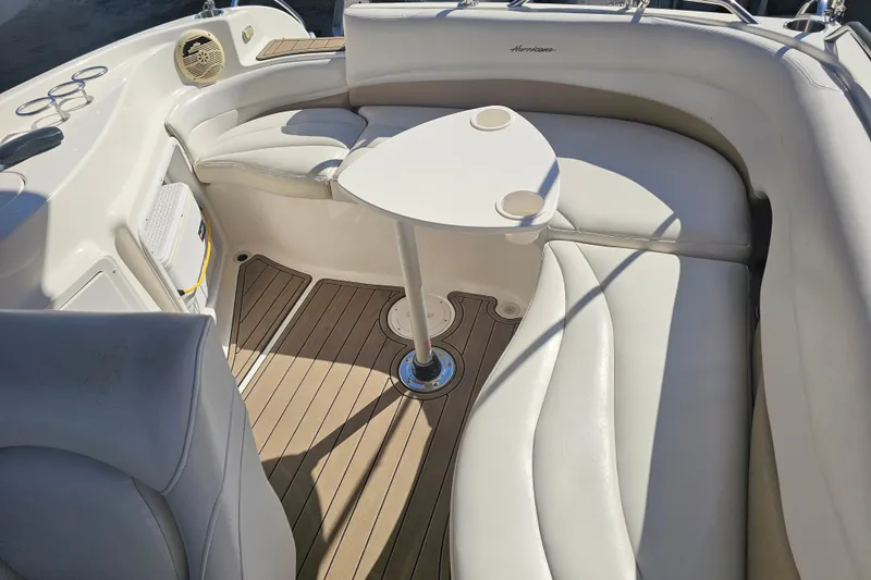 Slide: The Image of 2006 Hurricane SunDeck 260 OB boat interior with cushioned seating and table. - 11