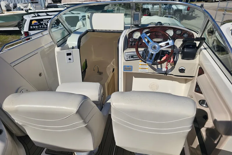 Slide: The Image of 2006 Hurricane SunDeck 260 OB boat interior with steering wheel and seating. - 14
