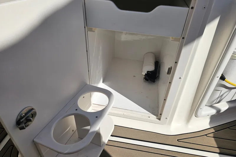 Slide: The Image of 2006 Hurricane SunDeck 260 OB storage compartment with cup holders and accessories. - 20
