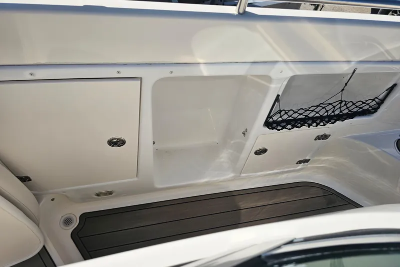 Slide: The Image of 2006 Hurricane SunDeck 260 OB interior with storage compartments and netting. - 21