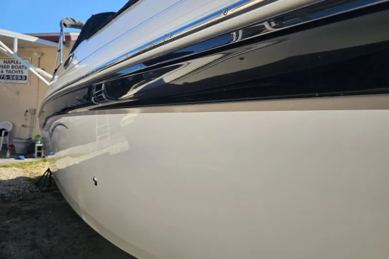 Slide: The Image of 2006 Hurricane SunDeck 260 OB boat side view, showcasing sleek design and glossy finish. - 5
