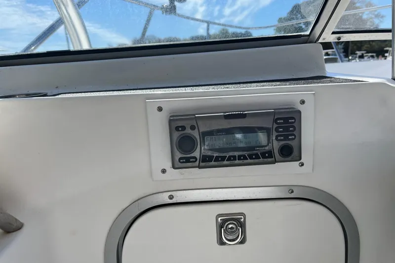 Slide: The Image of 1992 Bayliner Trophy 2000 boat dashboard with marine radio and clear sky view. - 10