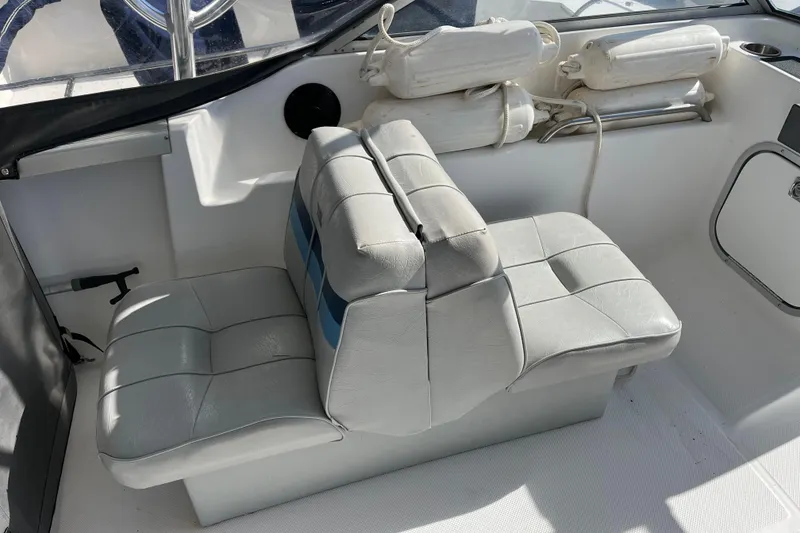 Slide: The Image of Interior seating of 1992 Bayliner Trophy 2000 boat with white cushions and blue accents. - 5
