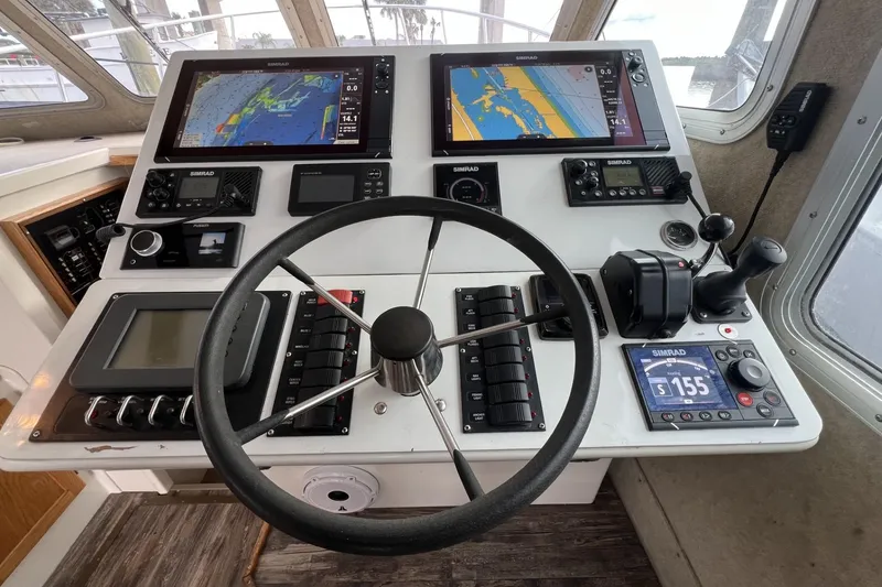 Slide: The Image of Control panel of a 2006 Provincial 42 Lobster Boat with navigation screens and steering wheel. - 17