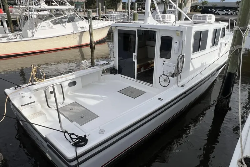 Slide: The Image of 2006 Provincial 42 Lobster Boat docked at marina, showcasing spacious deck and cabin. - 2