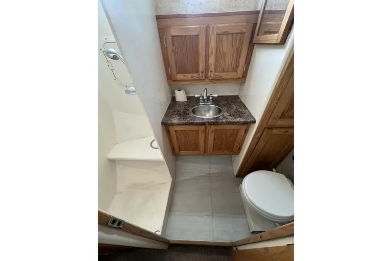Slide: The Image of 2006 Provincial 42 Lobster Boat bathroom with wooden cabinets, sink, and toilet. - 22