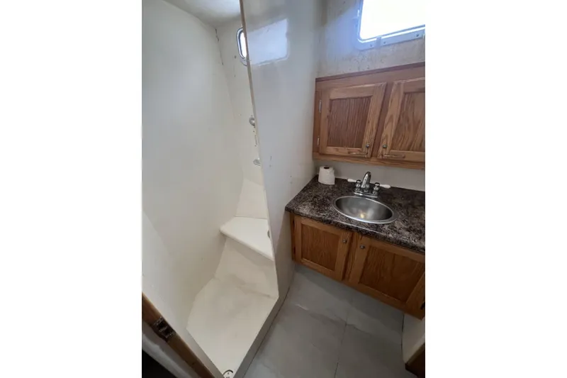 Slide: The Image of 2006 Provincial 42 Lobster Boat bathroom with shower, sink, and wooden cabinets. - 23