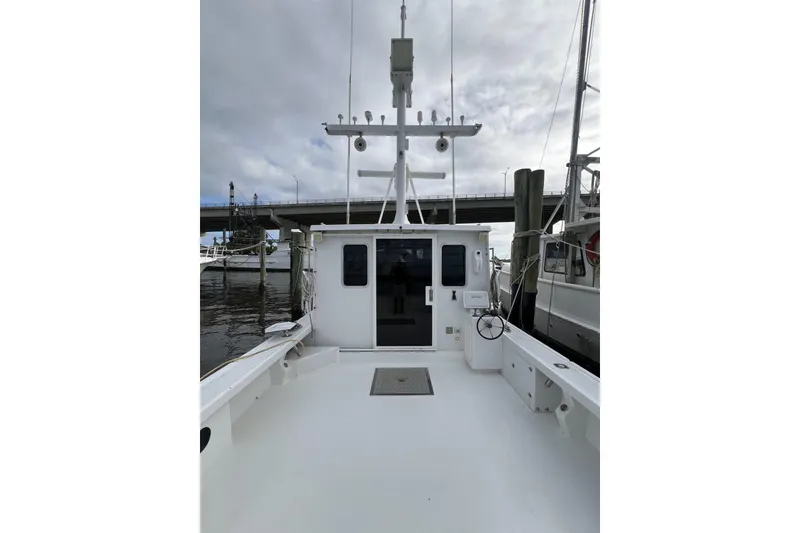 Slide: The Image of 2006 Provincial 42 Lobster Boat docked, showcasing spacious deck and cabin under cloudy skies. - 7