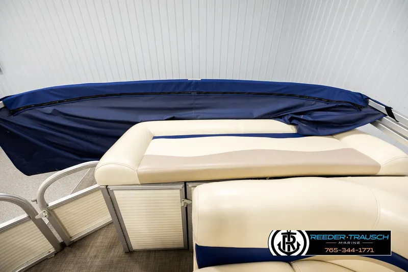 Slide: The Image of 2008 Sun Tracker Party Barge 24 with beige seating and blue cover in showroom. - 14