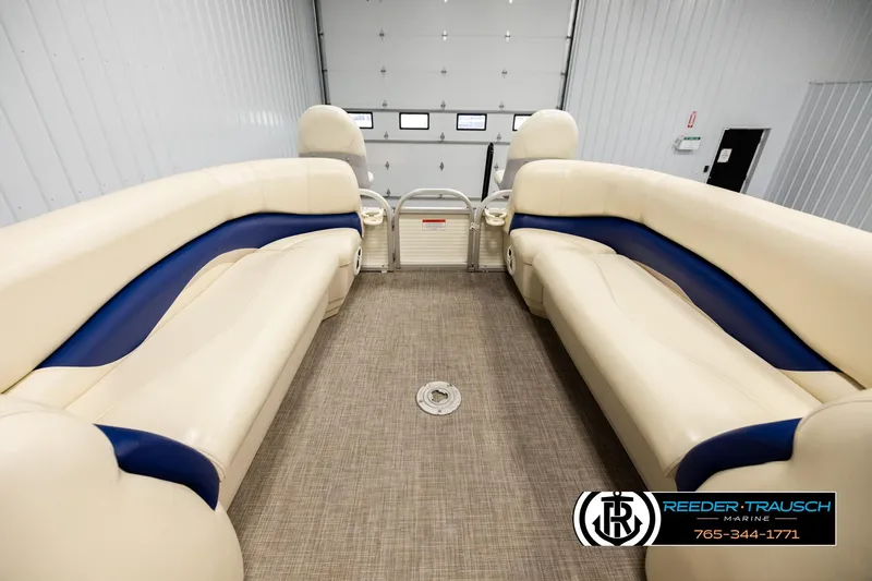 Slide: The Image of 2008 Sun Tracker Party Barge 24 interior with beige and blue seating in a showroom. - 17