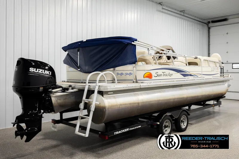 Slide: The Image of 2008 Sun Tracker Party Barge 24 pontoon boat with Suzuki outboard motor in indoor storage. - 5