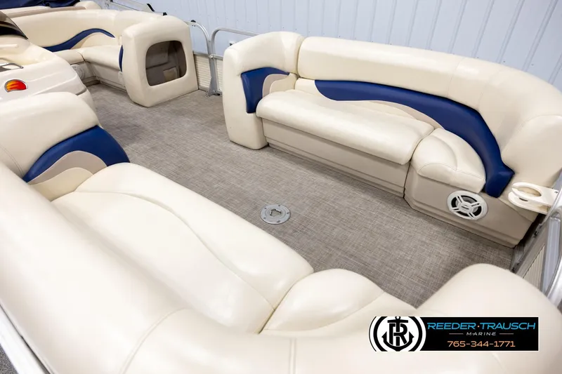 Slide: The Image of 2008 Sun Tracker Party Barge 24 interior with beige and blue seating, spacious layout. - 8
