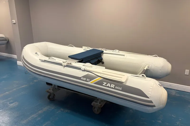 Slide: The Image of 2022 ZAR Mini 10 Lite inflatable boat displayed indoors on a blue floor. - 3